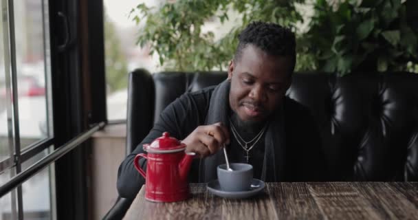 Afroamerykanin mieszający cukier w filiżance herbaty — Wideo stockowe