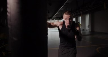 Boksör kum torbasına vuruyor, yavaş çekim 120 fps hızda 4K.