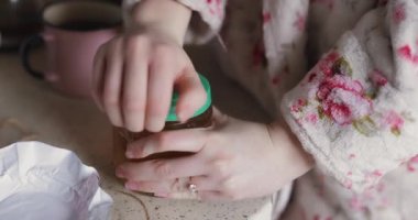 Kadın elleri bal kavanozunu açıyor.