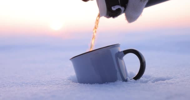Verter el té de un termo en una taza en un día frío de invierno — Vídeos de Stock