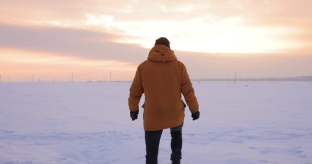 Agotado por el frío hombre cae en un campo cubierto de nieve — Vídeos de Stock