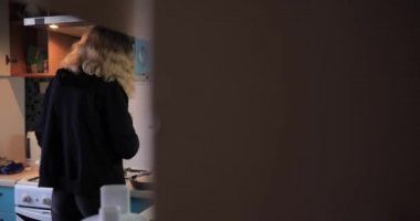 Ev rutini, kadın mutfakta yemek hazırlıyor.