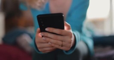 Evde akıllı telefon kullanan eller.