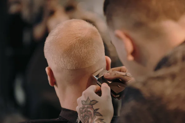 Hombre peluquero corte de pelo de su cliente — Foto de Stock