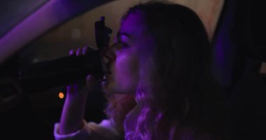 Geceleri arabada termostan çay içen bir kadın.