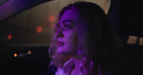 Portrait de belle femme assise dans une voiture la nuit — Video