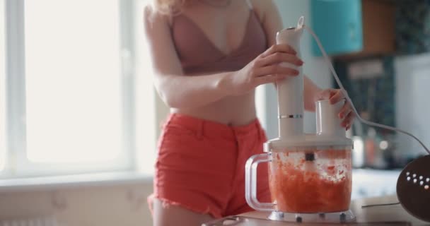 Donna sexy taglio carota su un frullatore a casa — Video Stock