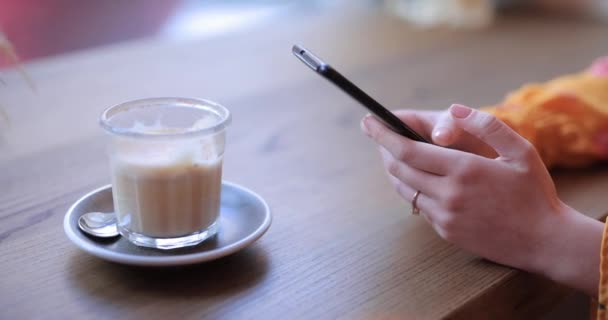 Las manos de la mujer usando el teléfono inteligente sentado en un café — Vídeo de stock