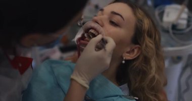 Ortodontist hastaların dişlerine diş teli takıyor.