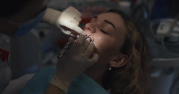 Ortodontista anexa um aparelho aos dentes pacientes — Vídeo de Stock