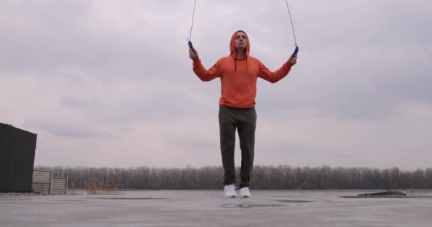 Young man skipping rope jumping outdoor — стоковое видео