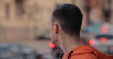 Man puts on earphones on the street