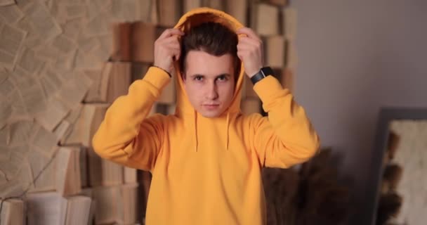 Man in yellow hoodie puts on hood at home, slow motion 4k at 120fps — Αρχείο Βίντεο