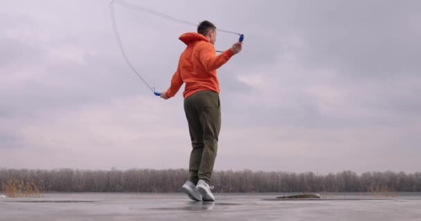 Young man skipping rope jumping outdoor — Stok video