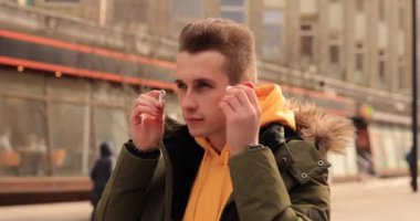 Stylish man puts on wireless earbuds into his ears