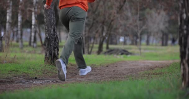 Мужские ноги бегают, бегают в парке, замедленная съемка — стоковое видео