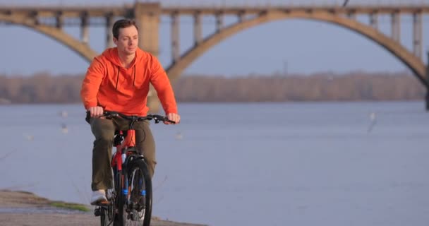 Radfahrer rast in Zeitlupe an Uferböschung — Stockvideo