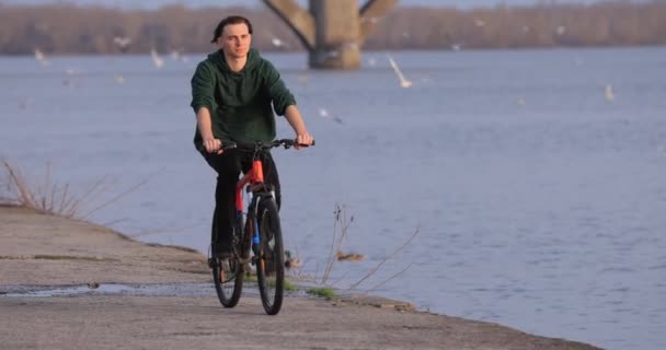 Велосипедист на велосипеде на набережной реки, замедленная съемка — стоковое видео