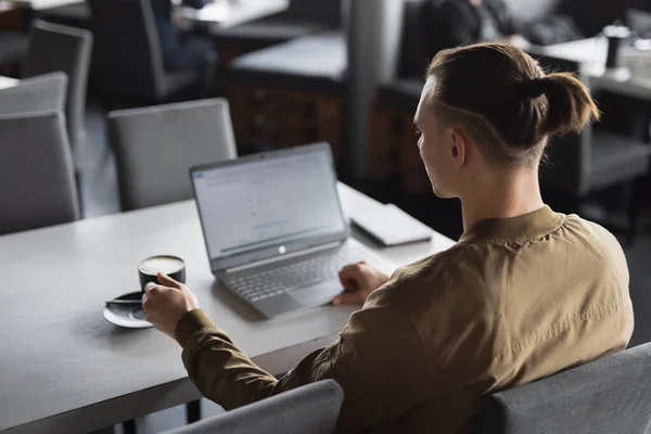 Freelancer man working by laptop PC in a cafe — Stock Photo, Image