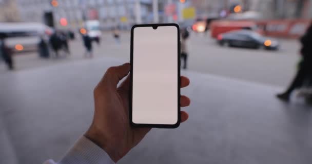 Mano masculina sosteniendo la maqueta del teléfono inteligente en una pantalla táctil izquierda de deslizamiento de la ciudad — Vídeos de Stock