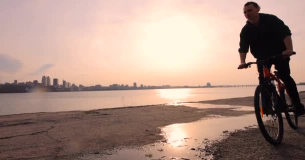 Bicicleta a caballo al atardecer, cámara lenta — Vídeos de Stock