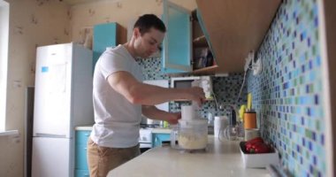 İnsan mikserde yemek karıştırıyor.