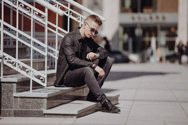 Giovane Uomo Moda Guarda Momento Suo Orologio Seduto Una Strada — Foto Stock