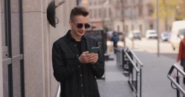 Şehirde telefonla gülen adam.