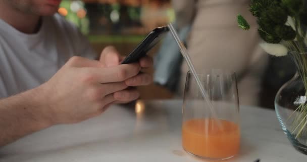 Manos masculinas usando smartphone sentado en el restaurante — Vídeo de stock