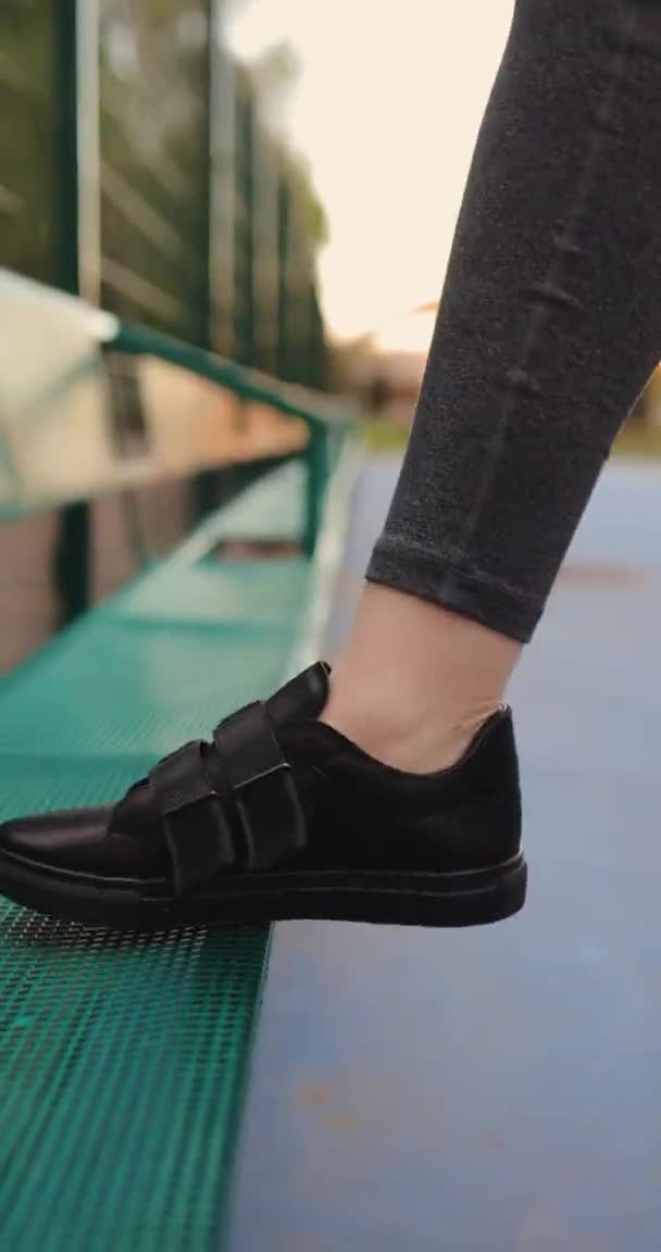 Closeup woman tying black shoe, vertical video — Stock Video