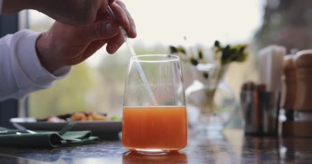 Fruity juice close up, unrecognizable man drinks it — Stock Video