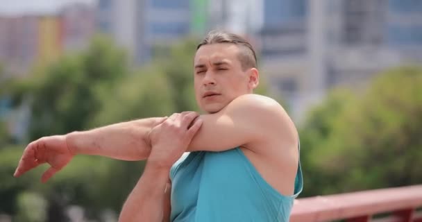 Спортсмен протягивает руки на мосту — стоковое видео