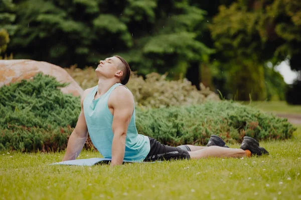 Člověk cvičí jógu v parku — Stock fotografie