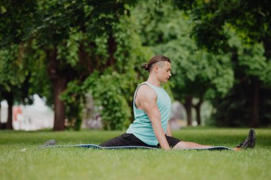 Adam parkta yoga egzersizi yapıyor.