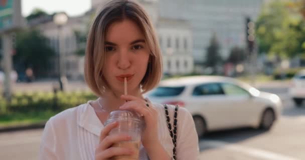 Mujer bebiendo café con leche fría en una ciudad — Vídeo de stock