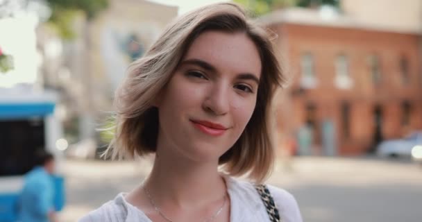 Улыбаясь короткие волосы женщина в городе замедленной съемки — стоковое видео