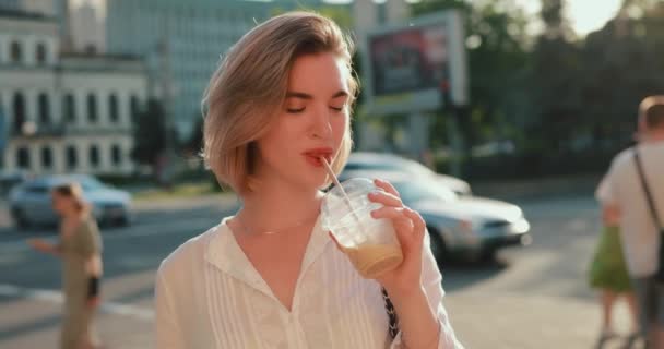 Щаслива жінка п'є холодні коктейлі в місті — стокове відео