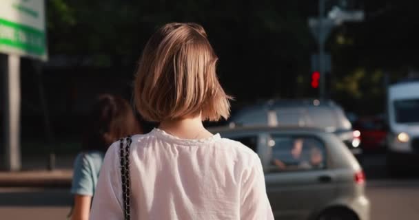 Nő áll út mellett egy városban, visszapillantás — Stock videók