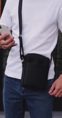 UKRAINE, DNEPR - 2 Temmuz 2021: Adam iPhone 'u kurye çantasına koydu
