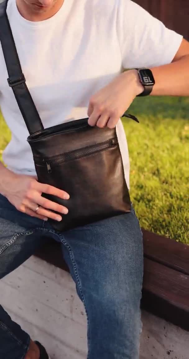 Man tar handväska från en budbärarväska — Stockvideo
