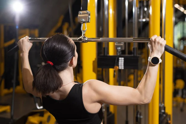 Womam fazendo exercício em aparelhos de treinamento em um ginásio — Fotografia de Stock