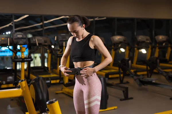 Deportiva mujer se sujeta el cinturón de gimnasio —  Fotos de Stock