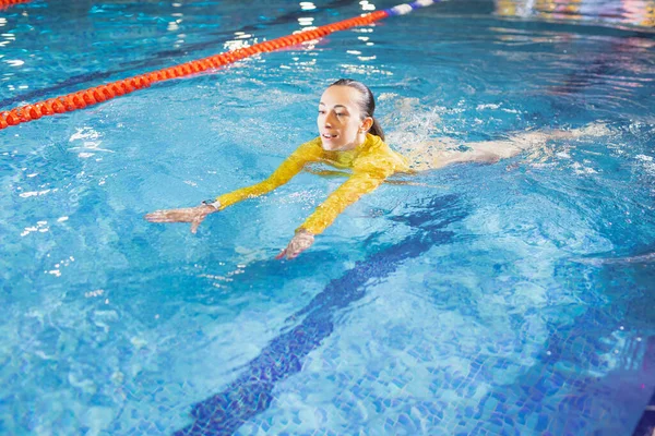 Mulher nadando na piscina interior — Fotografia de Stock