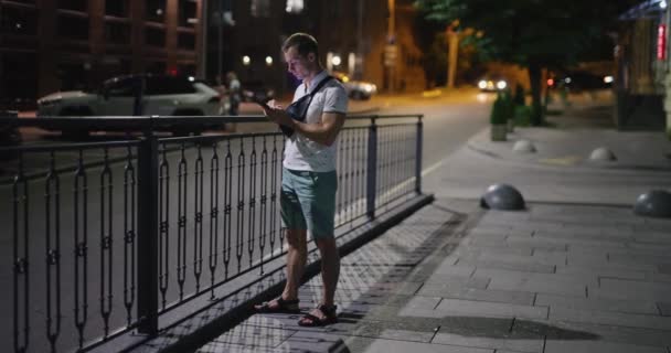 Hombre usando teléfono móvil en la ciudad nocturna — Vídeo de stock