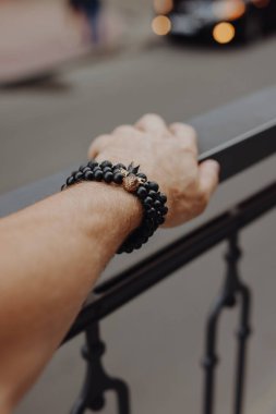 Erkek elinde şık bir siyah bilezik.