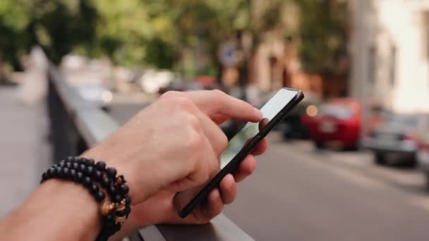 Mannelijke hand met smartphone close-up in de zomer stad — Stockvideo