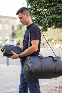 Şehirde siyah deri çantalı bir adam dolaşıyor.
