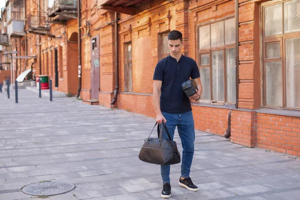 Чоловік ходить у місті з чорною шкіряною сумкою — стокове фото
