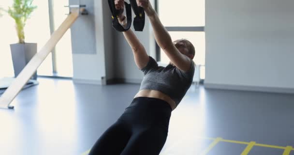 Vrouw die traint op TRX-bandjes — Stockvideo