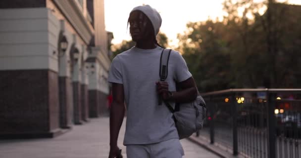 Afrika kökenli Amerikalı bir adam yavaş çekimde şehirde yürüyor. — Stok video